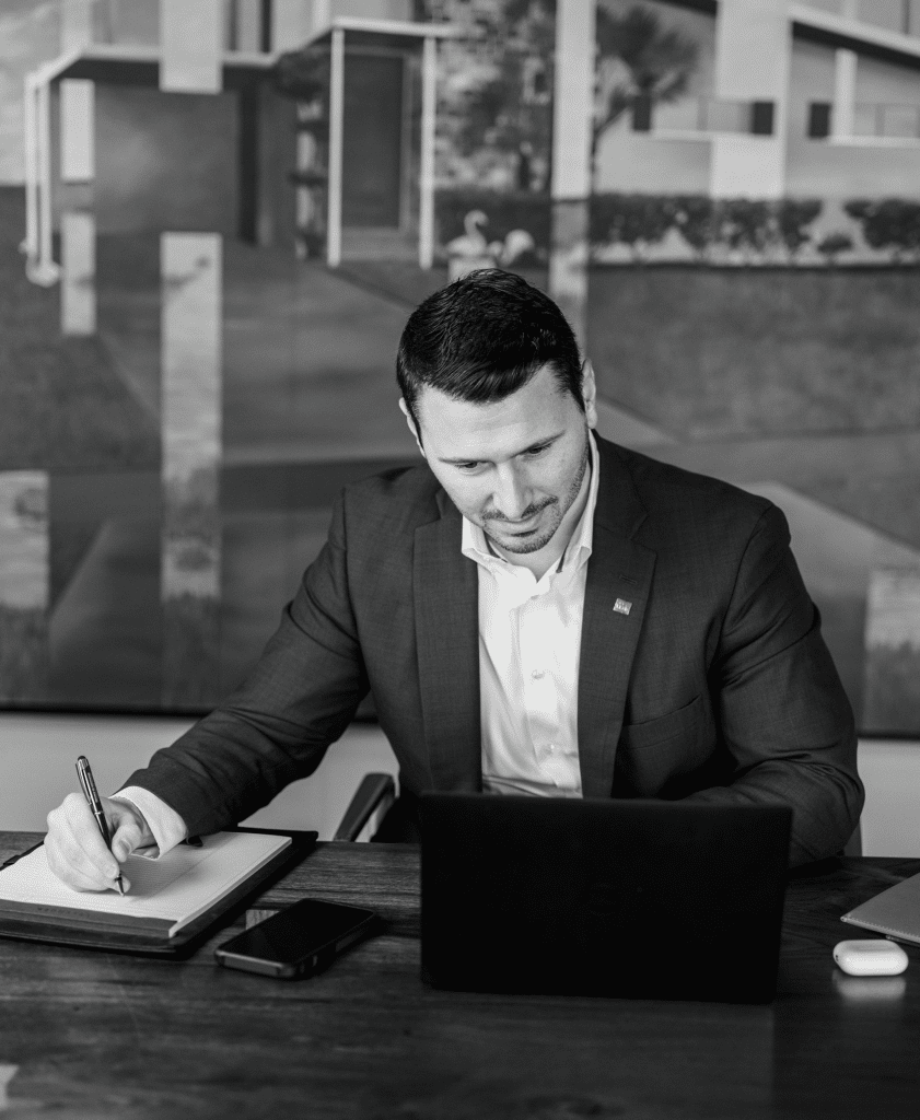Hunter looking at a laptop while writing on a notepad